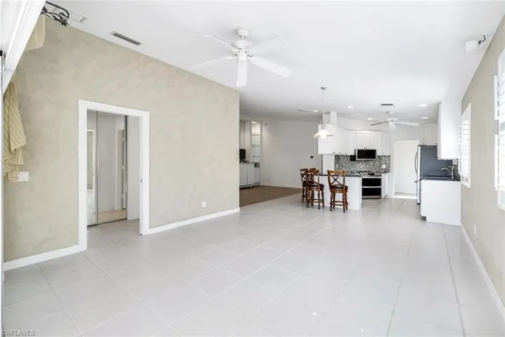 Living area featuring light tile patterned floors and a ceiling fan