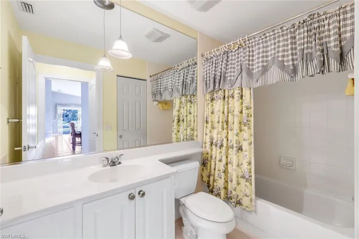 Bathroom featuring vanity and shower / tub combo with curtain