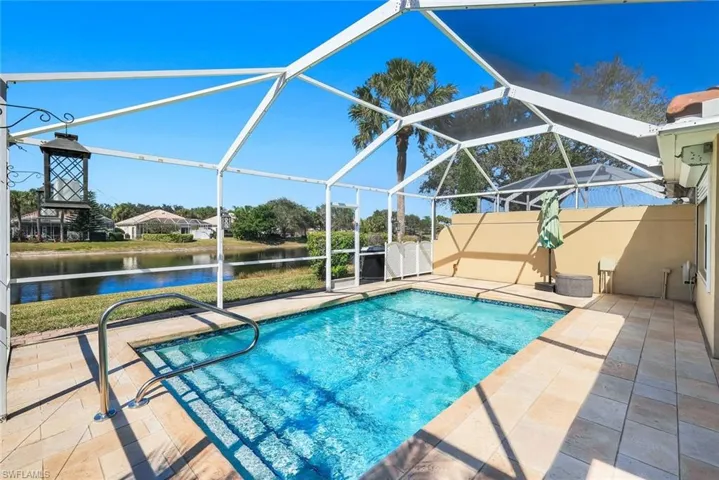 Swimming pool featuring a sunroom, a patio area, a lanai, and a water view