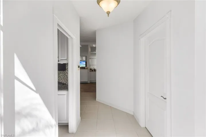 Corridor with baseboards and light tile patterned flooring