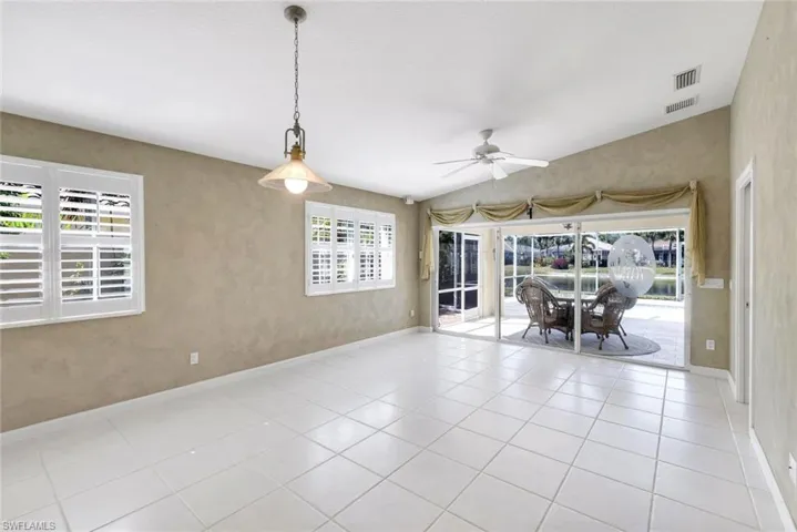 Spare room featuring vaulted ceiling, ceiling fan, light tile patterned flooring, and a sunroom