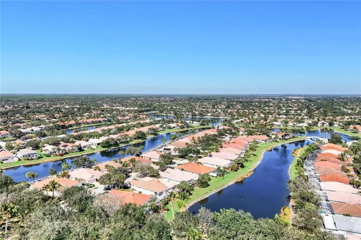 Aerial perspective of suburban area featuring a nearby body of water