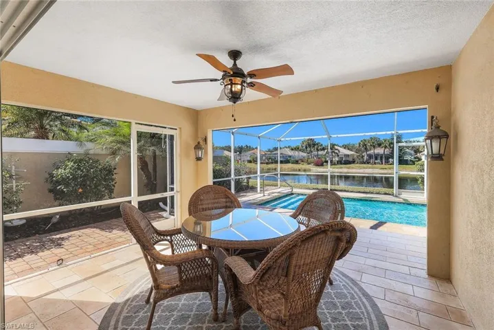 Sunroom / solarium with a ceiling fan, a patio, and a water view