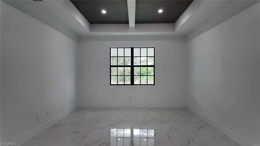 Empty room featuring a tray ceiling