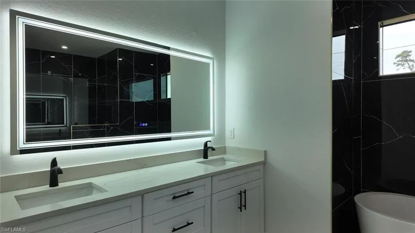 Bathroom with a tub to relax in and vanity