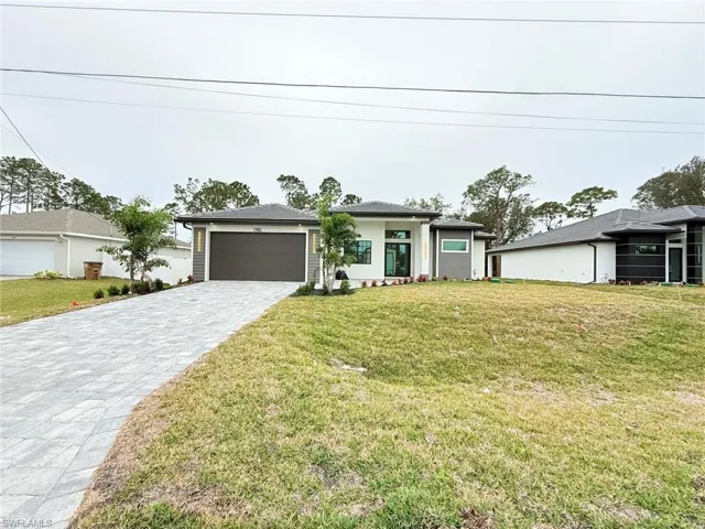 View of front of home featuring a front lawn and a garage