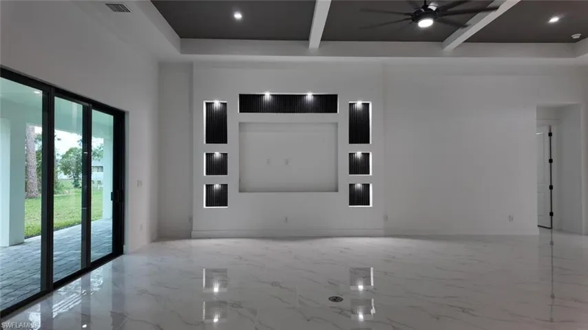 Spare room featuring ceiling fan, french doors, a towering ceiling, and beamed ceiling