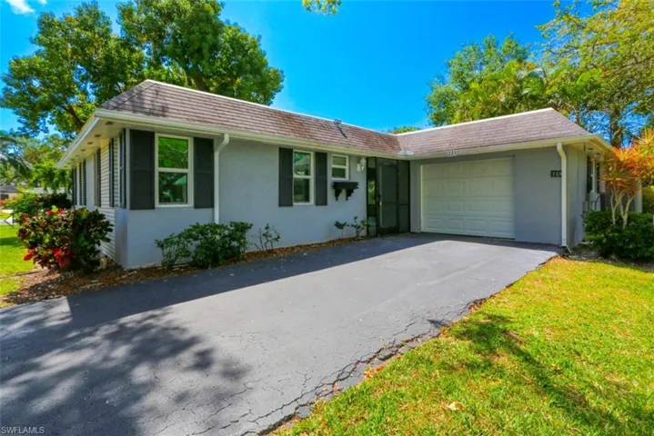 Single story home with a garage and a front yard