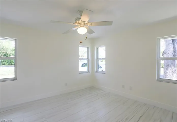 Empty room with ceiling fan and a healthy amount of sunlight
