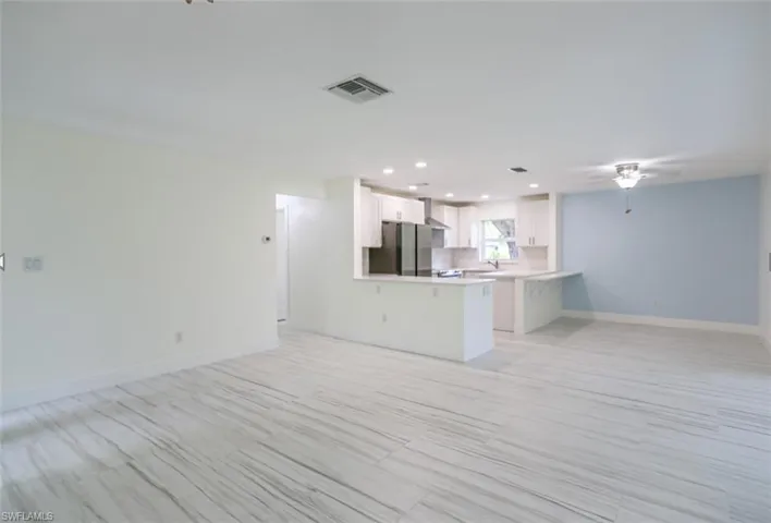 Unfurnished living room featuring sink and ceiling fan