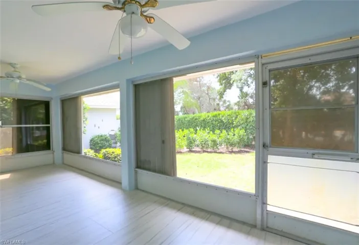 Unfurnished sunroom with ceiling fan and lofted ceiling