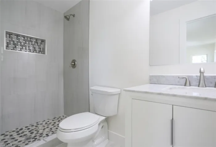 Bathroom with vanity, toilet, and a tile shower