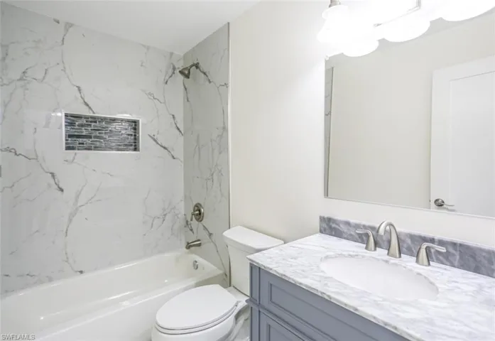 Full bathroom featuring toilet, vanity, and tiled shower / bath