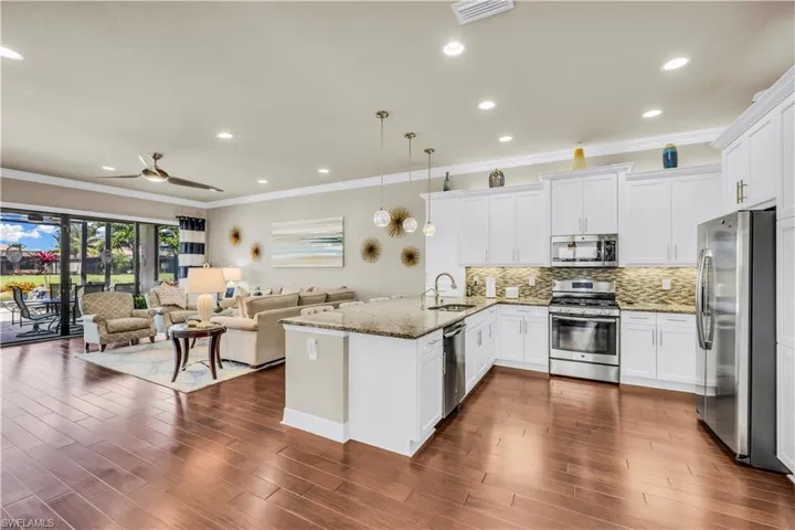 Open kitchen with granite counters, stainless steel appliances, high level cabinets with upper and under cabinet lighting, built-in pantry.