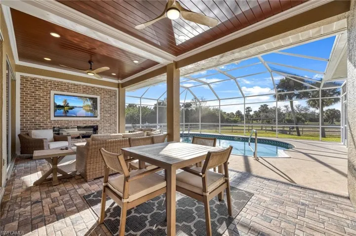 View of patio featuring an outdoor hangout area, ceiling fan, and glass enclosure