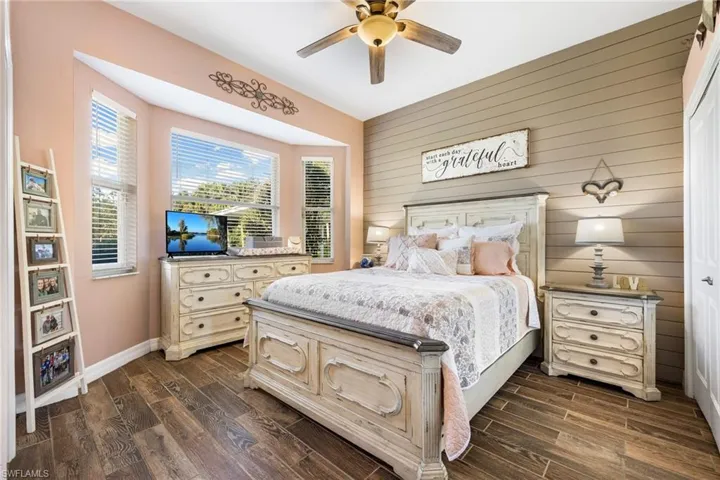 Bedroom with dark hardwood / wood-style floors and ceiling fan