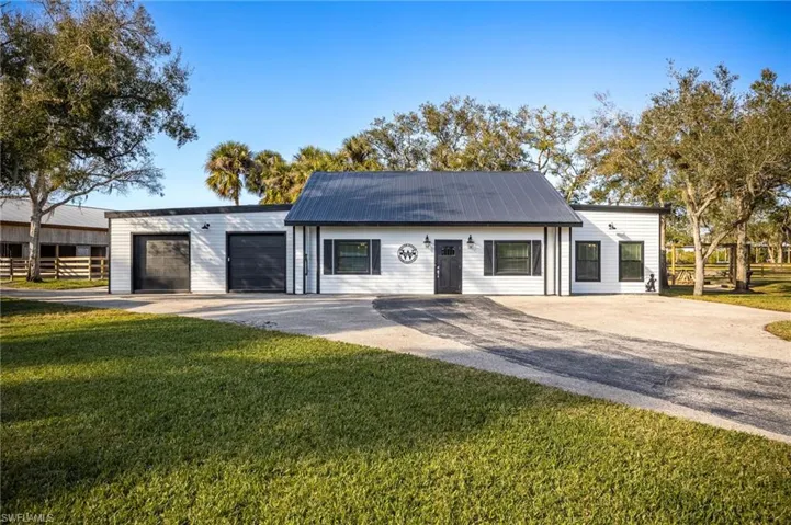 View of front of home with a garage and a front lawn