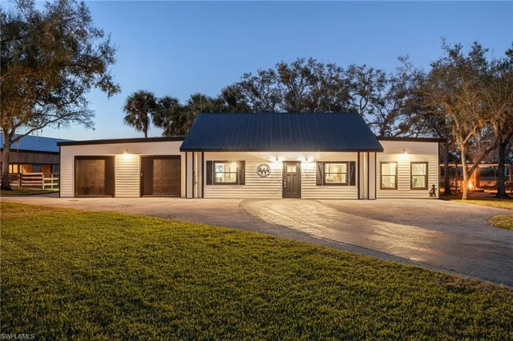 View of front of home featuring a garage and a yard