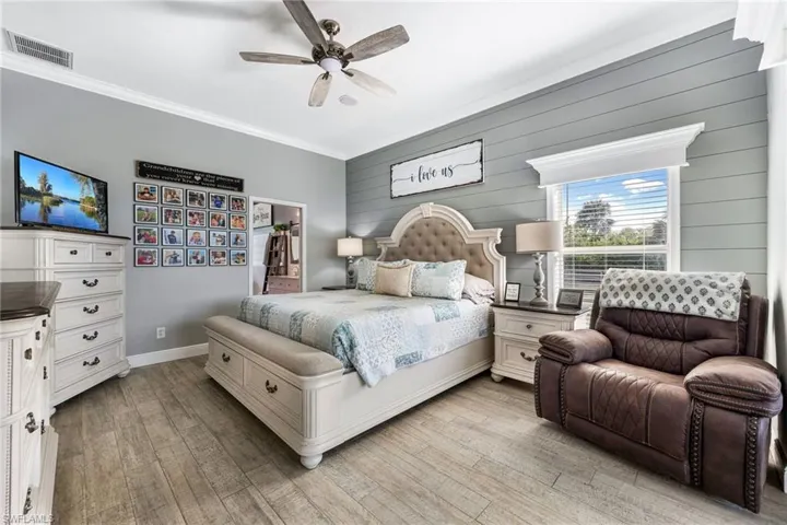Bedroom with crown molding, ceiling fan, and light hardwood / wood-style flooring