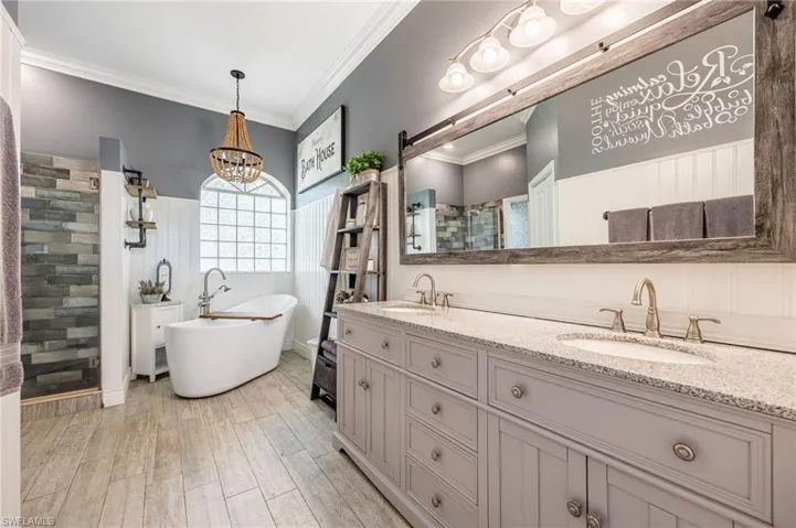 Bathroom featuring vanity, hardwood / wood-style floors, crown molding, and separate shower and tub
