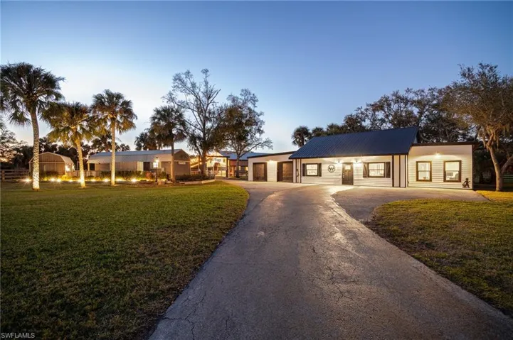 Single story home featuring a garage and a lawn