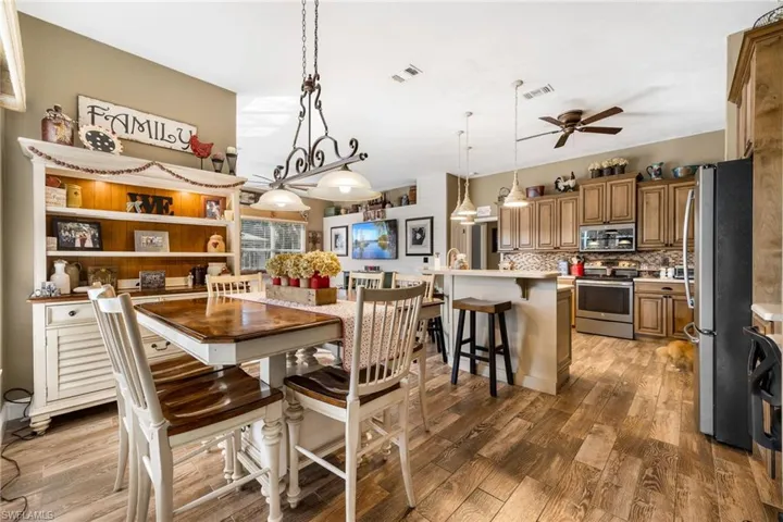 Dining room with dark wood-type flooring and ceiling fan