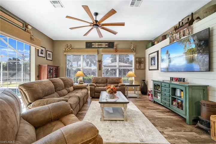 Living room featuring hardwood / wood-style floors, a healthy amount of sunlight, and ceiling fan