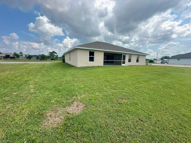 Back of house with a lawn