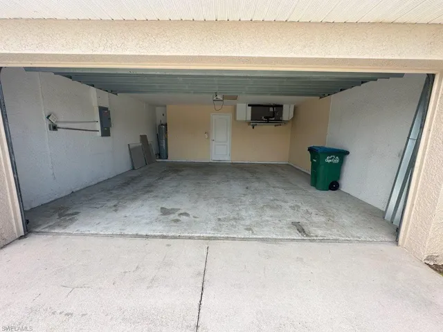Garage featuring electric water heater and electric panel