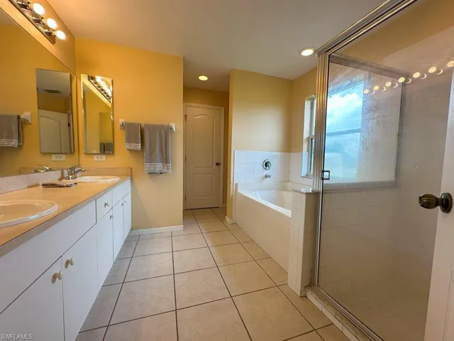Bathroom with double vanity, plus walk in shower, Separate Tub and tile patterned floors