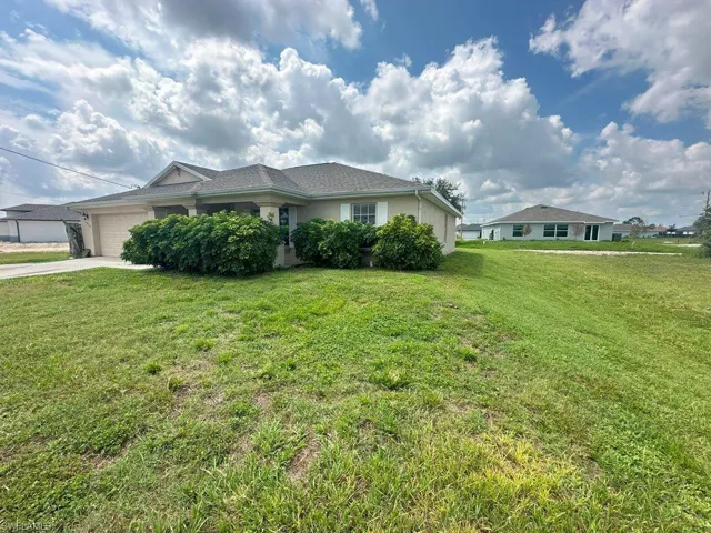 Single story home with a front lawn and a garage