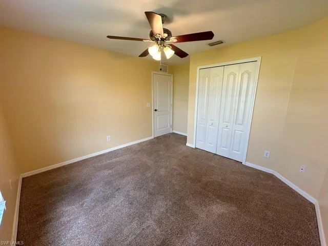 bedroom 3 with ceiling fan and carpet floors