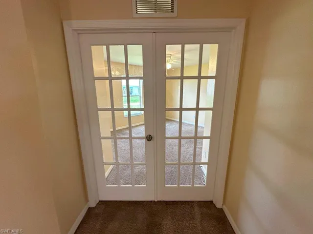 Entryway featuring dark colored carpet and french doors