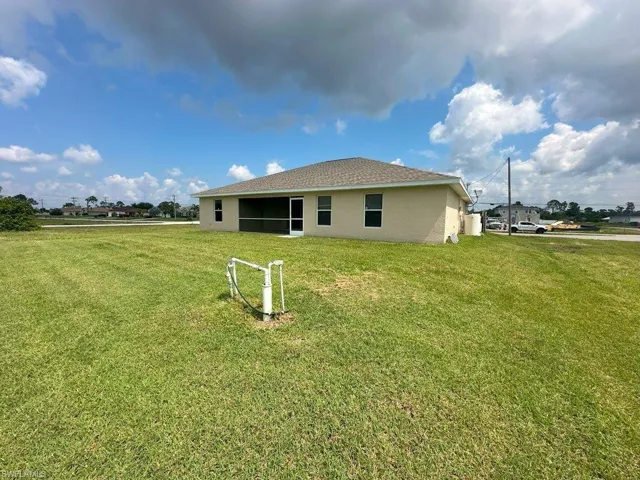 Rear view of house featuring a lawn