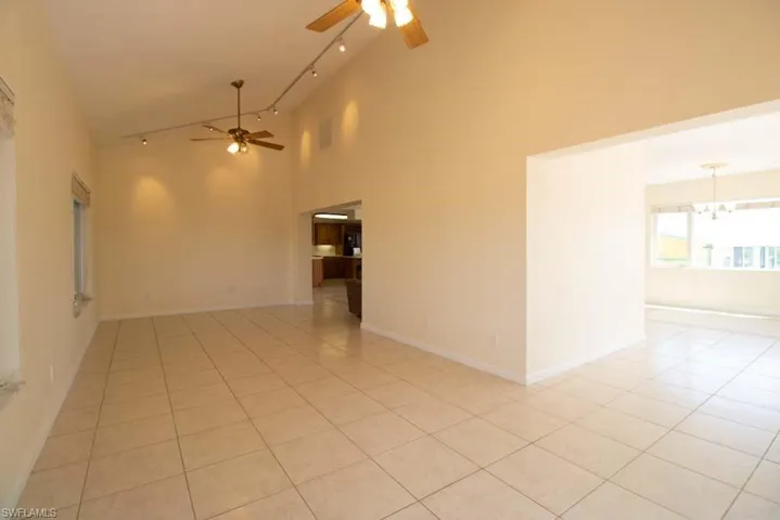 Empty room featuring light tile patterned floors, a chandelier, and inlaid floor details