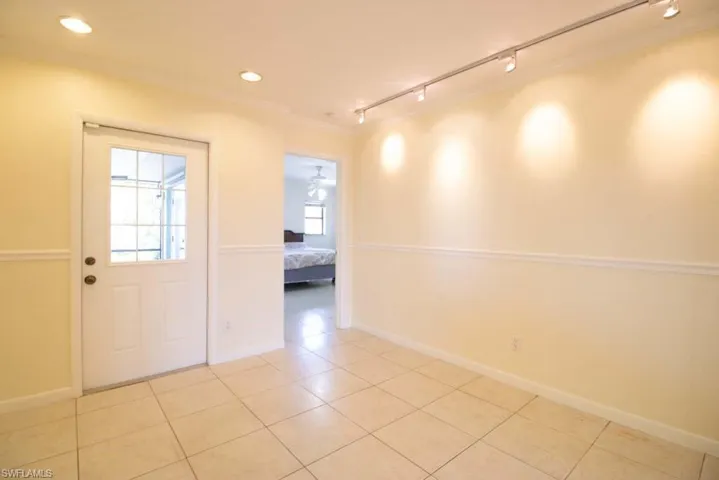Bathroom featuring crown molding, vanity, light tile patterned flooring, enclosed tub / shower combo, and recessed lighting