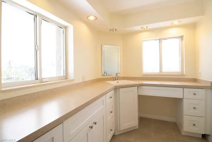 Unfurnished office with light tile patterned floors and a sink