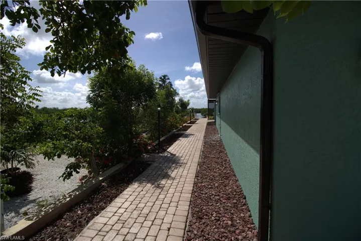 Back of property featuring a sunroom, a lanai, an outdoor pool, stucco siding, and french doors