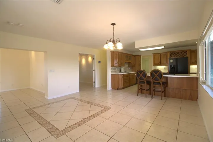 Empty room with light tile patterned floors, high vaulted ceiling, and ceiling fan