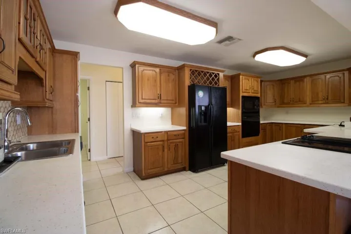 Spare room with a chandelier, stairway, and light tile patterned flooring
