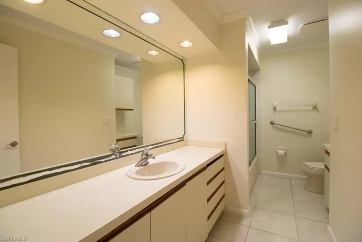 Empty room featuring light tile patterned floors, ornamental molding, and a ceiling fan
