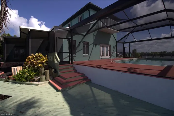 Dock area with a water view, boat lift, and a sunroom