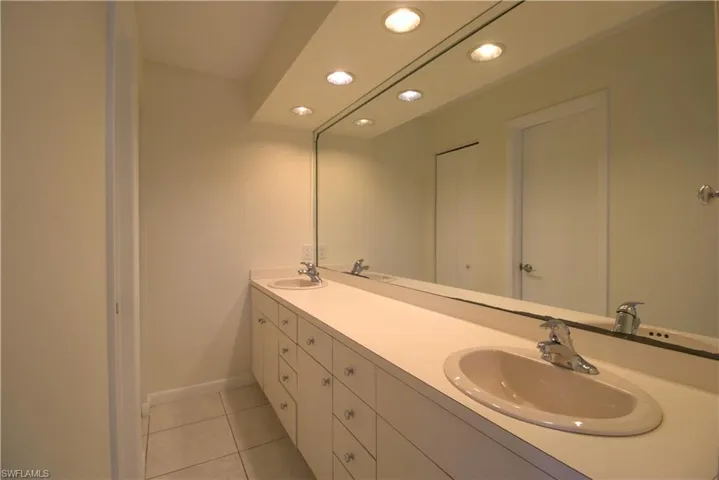 Bedroom with french doors, light tile patterned floors, access to outside, and a ceiling fan