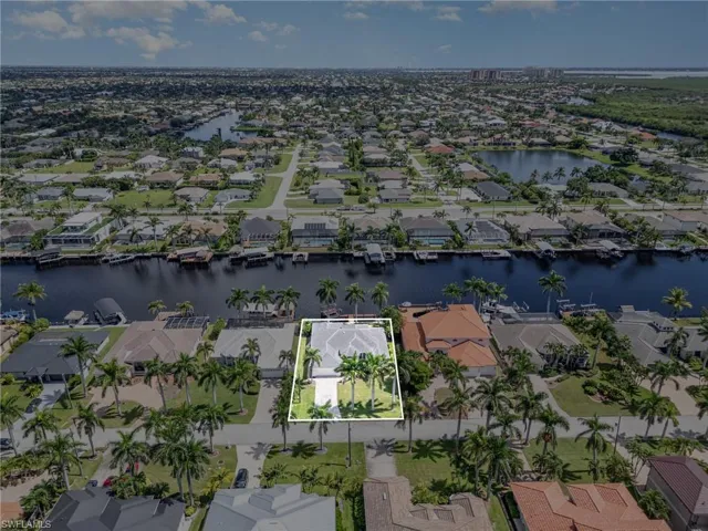 Aerial view of residential area featuring a large body of water and property boundaries highlighted