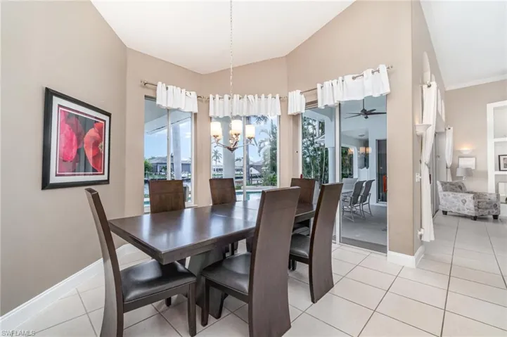 Dining space featuring light tile patterned flooring, a chandelier, and a ceiling fan
