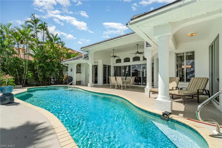 Outdoor pool with a patio area, ceiling fan, and outdoor dining space