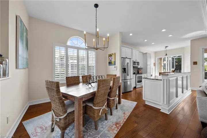 Dining area featuring a chandelier, plenty of natural light, dark wood-type flooring, and sink