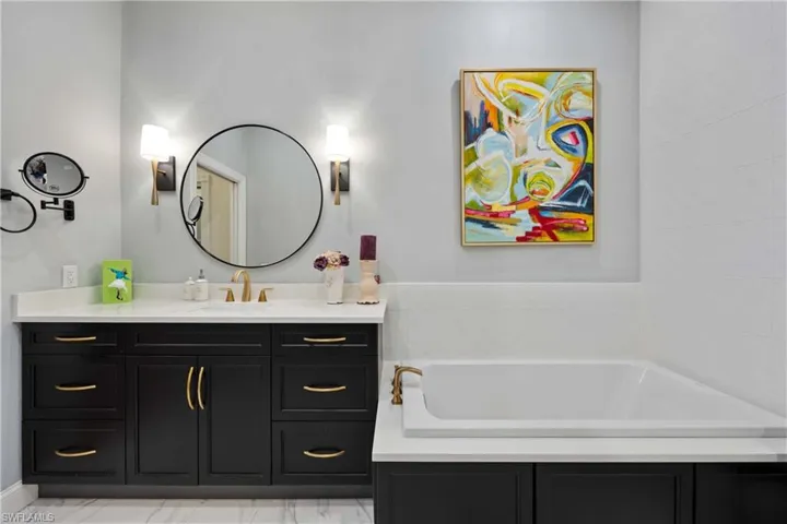 Bathroom with vanity and a washtub