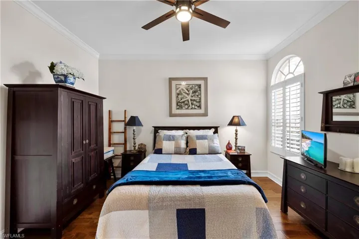 Bedroom featuring crown molding, ceiling fan, and dark wood-type flooring