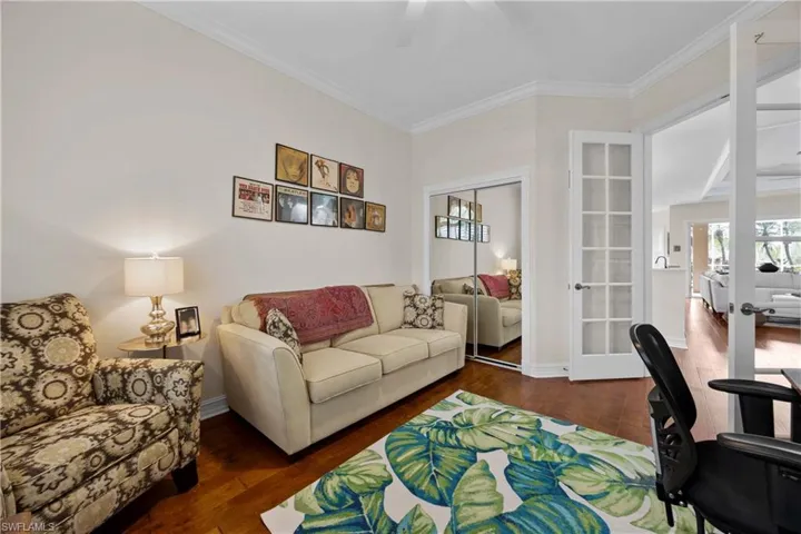 Living room with crown molding, french doors, and dark wood-type flooring